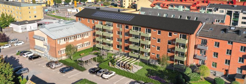 3D-visualisering av fasad mot baksidan efter renovering. Fyravåningshus i mörkbrunt tegel, med svarta takpannor. Balkongfronter i ljust grön sinusplåtprofil. Innergård med gräsyta, planteringar, buskar, träd och pergola med grill.