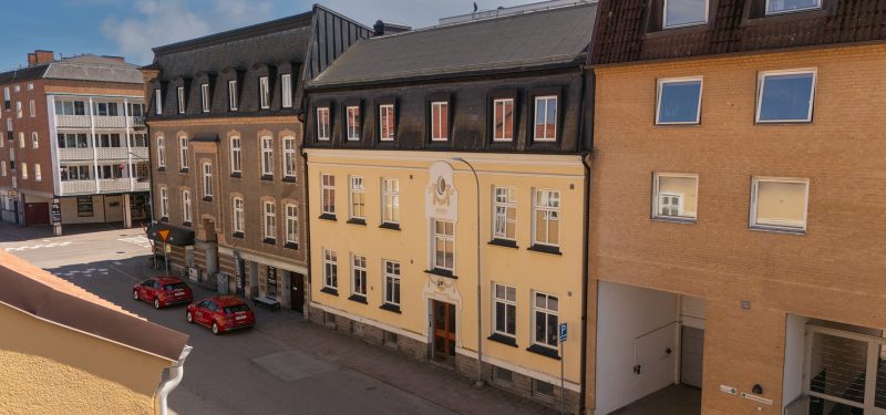 Vaktgatan 6-8, halv våning längre än Östergatan 59. Gul putsfasad med vita fasaddetaljer. Vita flaggfönster och svart shingel- samt plåttak.