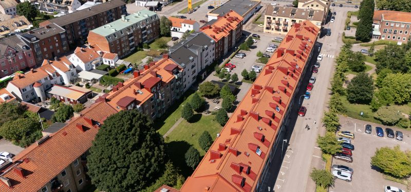 Flygvy över våra kvarter vid Nya Torg, Gasverksgaran 23-27 samt Fasangatan 4-10. Visar långa takåsar med tegelpannor, grönskanske innergård och delar av Nya Torgs park i högra hörnet.