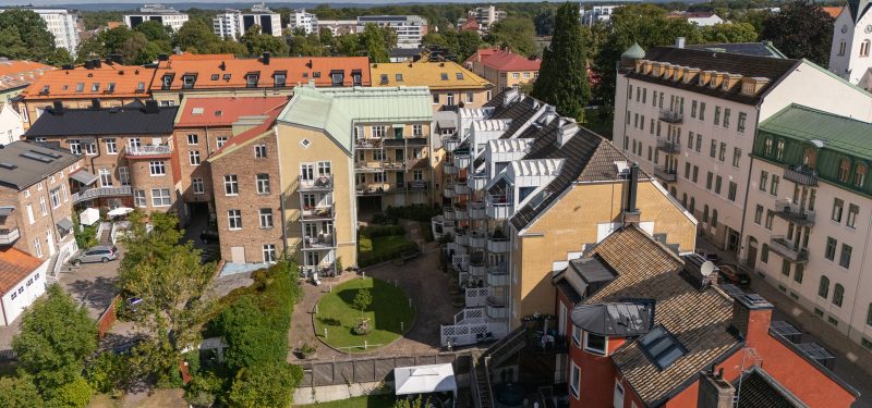 Flygvy över Västra Kyrkogatan 5-7 samt Järnvägsgatan 27 och dess innergård med gräsyta och plattlagd gång.