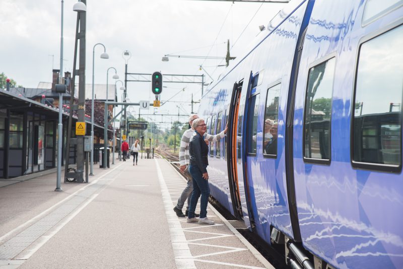 Pågatåg inne på stationen med människor som går ombord. Klimatsmart resande!